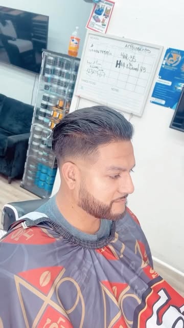 A client in the cape getting a haircut at MVP Barbershop